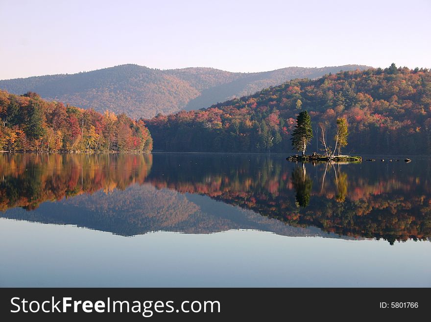 Autumn reflection of forested hills in a New England pond