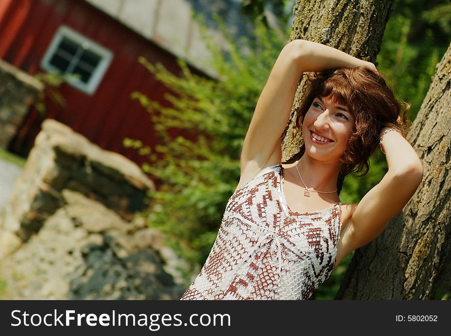 Pretty girl leaning against a tree. Pretty girl leaning against a tree.