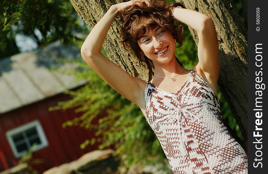 Pretty girl leaning against a tree. Pretty girl leaning against a tree.