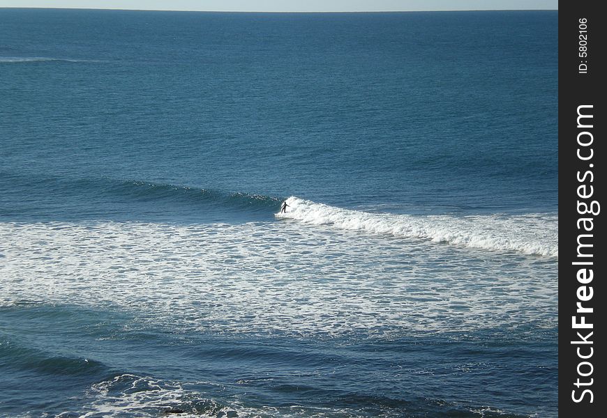 A lone surfer at Moffatt beach, in Queensland Australia