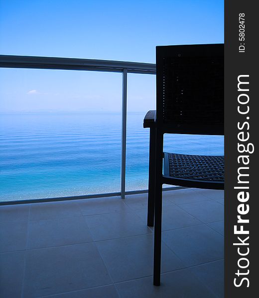 Empty chair overlooking a calm afternoon sea. Empty chair overlooking a calm afternoon sea