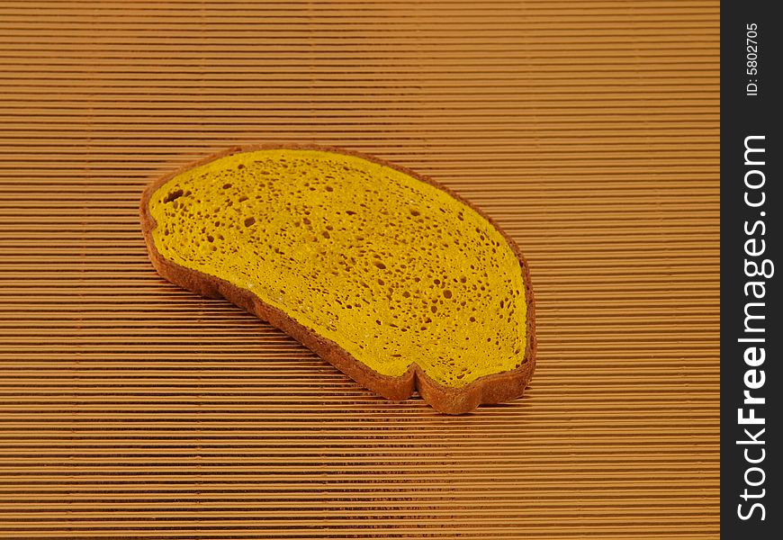 Yellow slice of bread on golden corrugated  board. Yellow slice of bread on golden corrugated  board