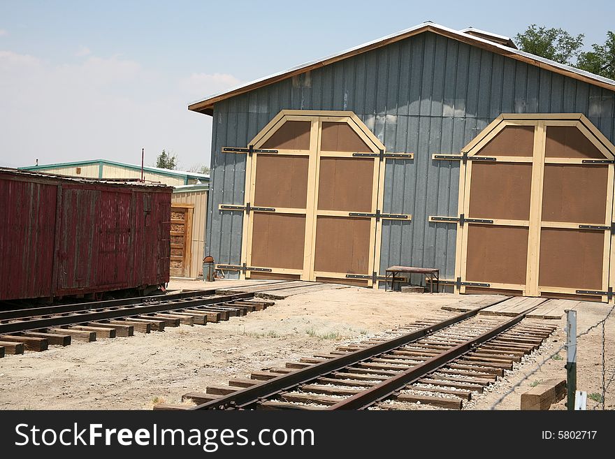 Railroad tracks and ties leading to a storage building at a train station or depot