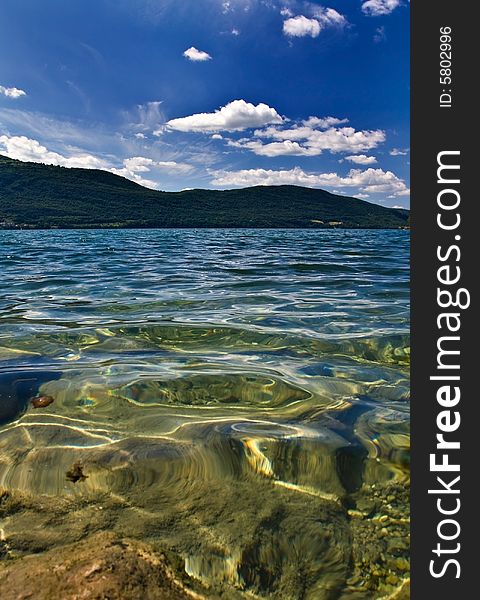 Lake on sunny day with clear water - vertical. Lake on sunny day with clear water - vertical