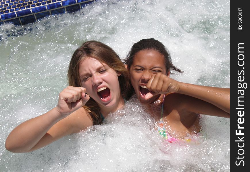 A picture of two tween girls in a jacuzzi prentending to be lead singers of a rock band. A picture of two tween girls in a jacuzzi prentending to be lead singers of a rock band.