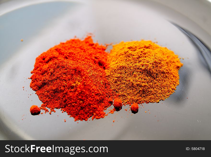 Two different spices on a dark desk : red sweet paprika, and indian curry. Two different spices on a dark desk : red sweet paprika, and indian curry