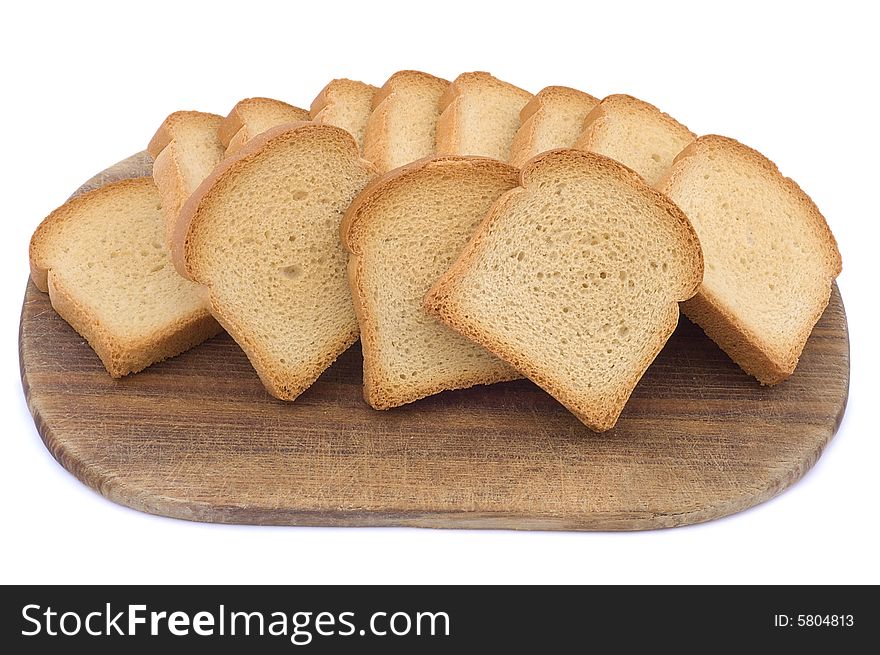 Pieces of toast on a wooden hardboard isolated on white. Close-up