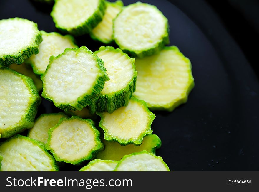 Some sliced zucchini on a dark desk