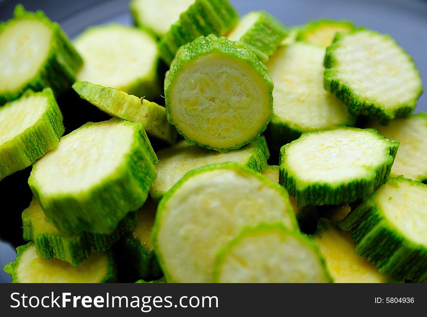 Sliced zucchini on a dark desk in the Kitchen. Sliced zucchini on a dark desk in the Kitchen