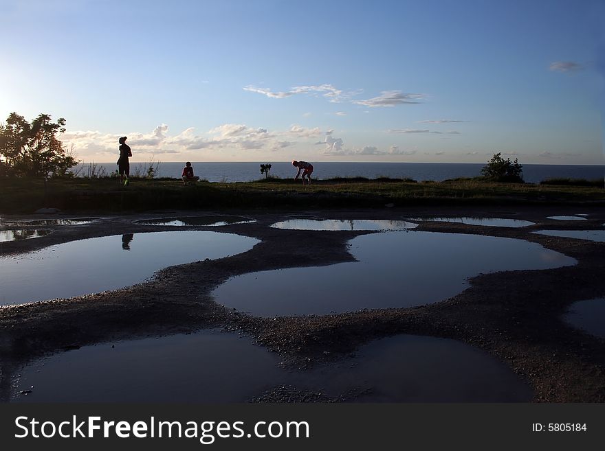 Pools and silhouettes of people on a coast of Baltic sea