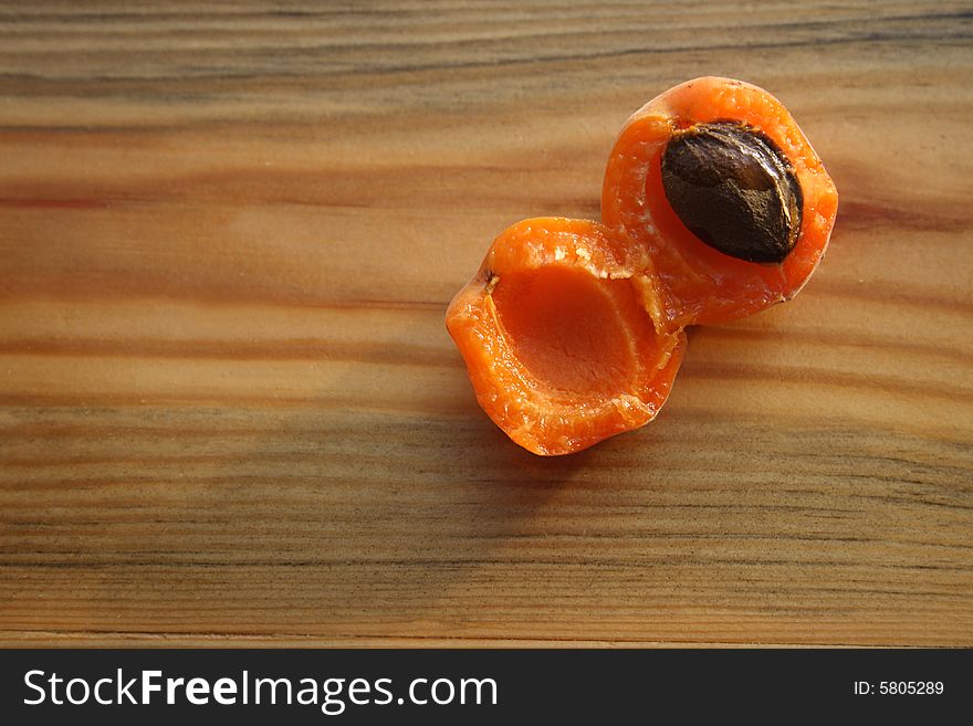 Two half of apricot on wooden background