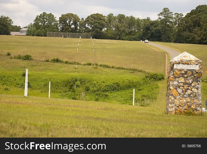 This stone marker sits on the site of the southeast corner of the Andersonville prison stockade during the Civil War. The line of white posts to the left marks the dead line. This stone marker sits on the site of the southeast corner of the Andersonville prison stockade during the Civil War. The line of white posts to the left marks the dead line.