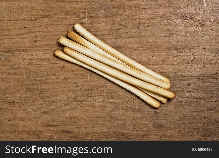 Bunch of Bread sticks on a wooden table.