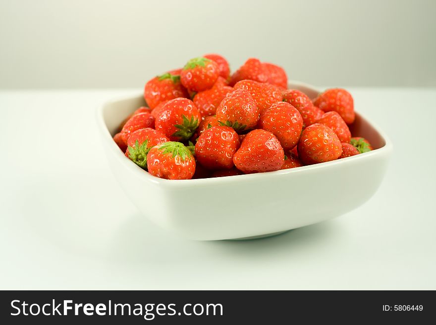 Strawberry in white bowl on white background