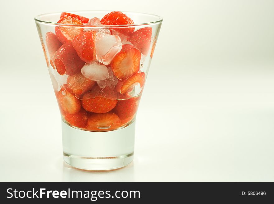 Strawberry in glass with ice on white background