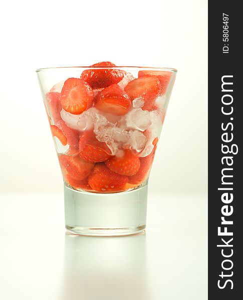 Strawberry in glass with ice on white background