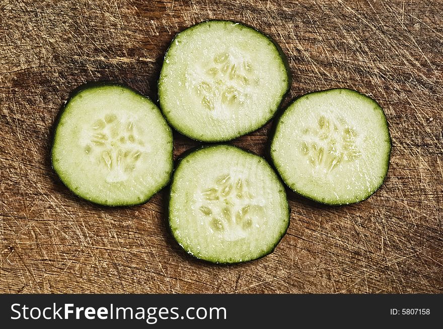 Slices of cucumber on a wooden background.