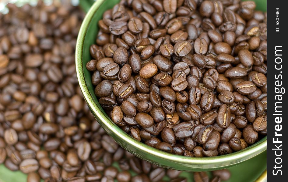 Coffee beans in green cup. Coffee beans in green cup