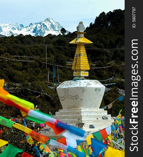 Tibetan tower and prayer flag with snow mountain in background,Yunnan,china