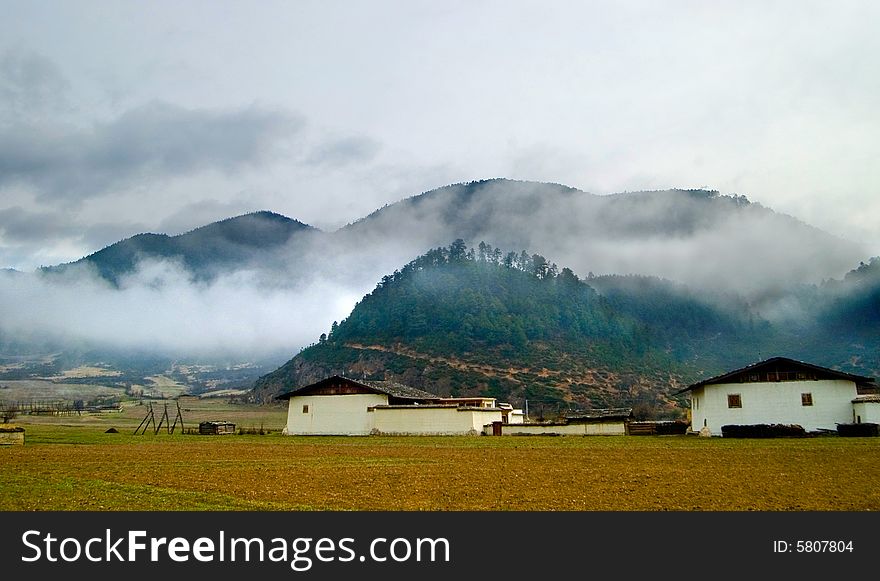 Tibetan village with mountian and clouds in background,Yunnan,china