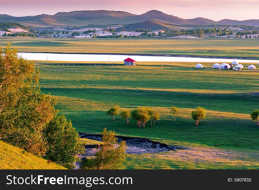 Meadow at dawn with mountain and river,china