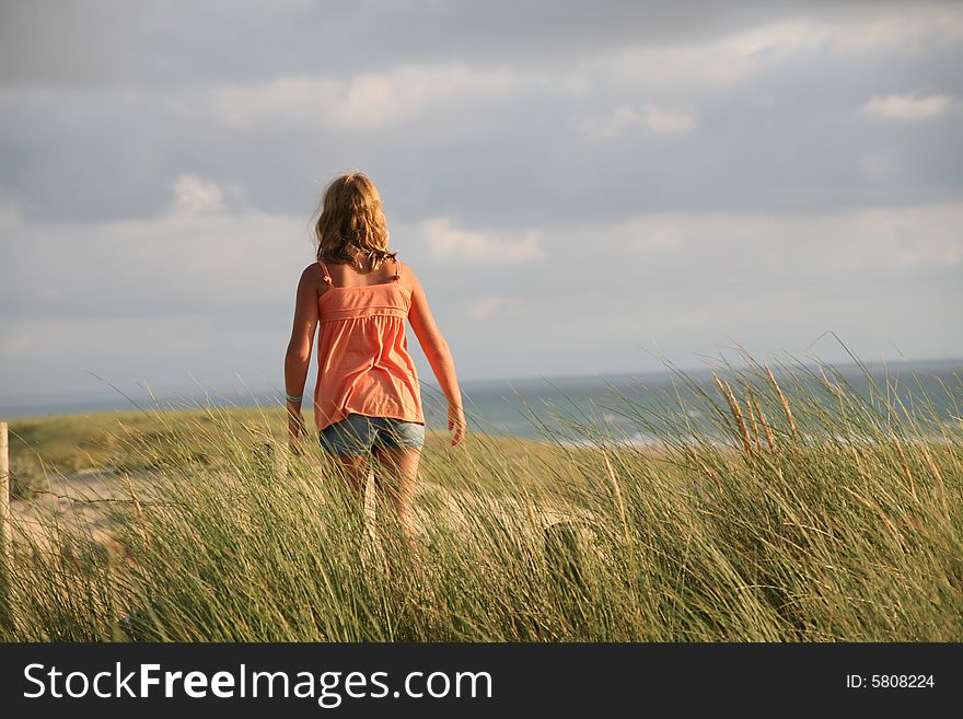 Happy girl on the dune in sunset light, happy holidays in France on the Atlantic ocean shore. Happy girl on the dune in sunset light, happy holidays in France on the Atlantic ocean shore