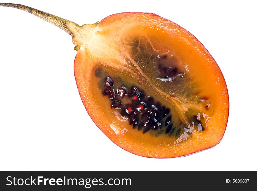 Cut half of a fresh Tamarillo fruit showing its deep red seeds and tangy sweet flesh. Cut half of a fresh Tamarillo fruit showing its deep red seeds and tangy sweet flesh