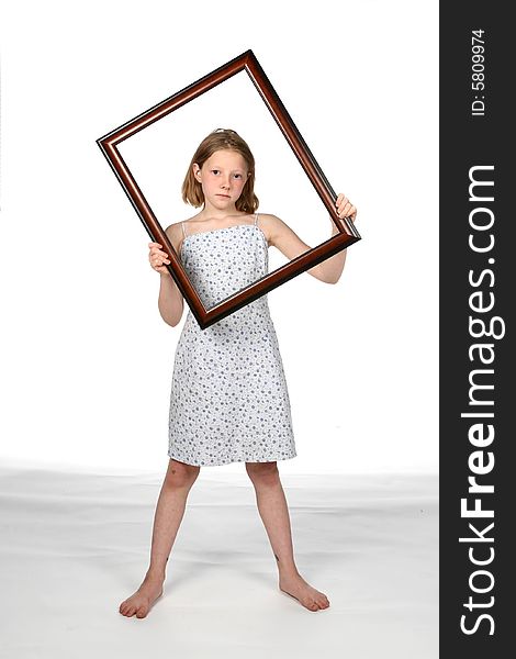 Girl in dress holding a frame around her face. Girl in dress holding a frame around her face