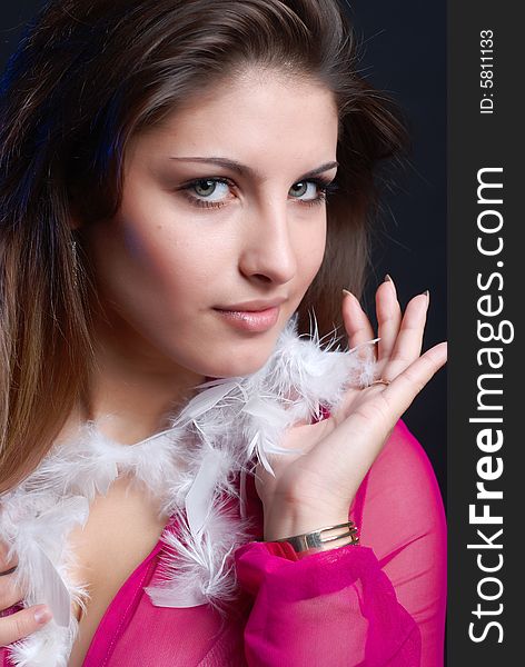 Portrait of young girl in a pink smock with white feathers around. Portrait of young girl in a pink smock with white feathers around