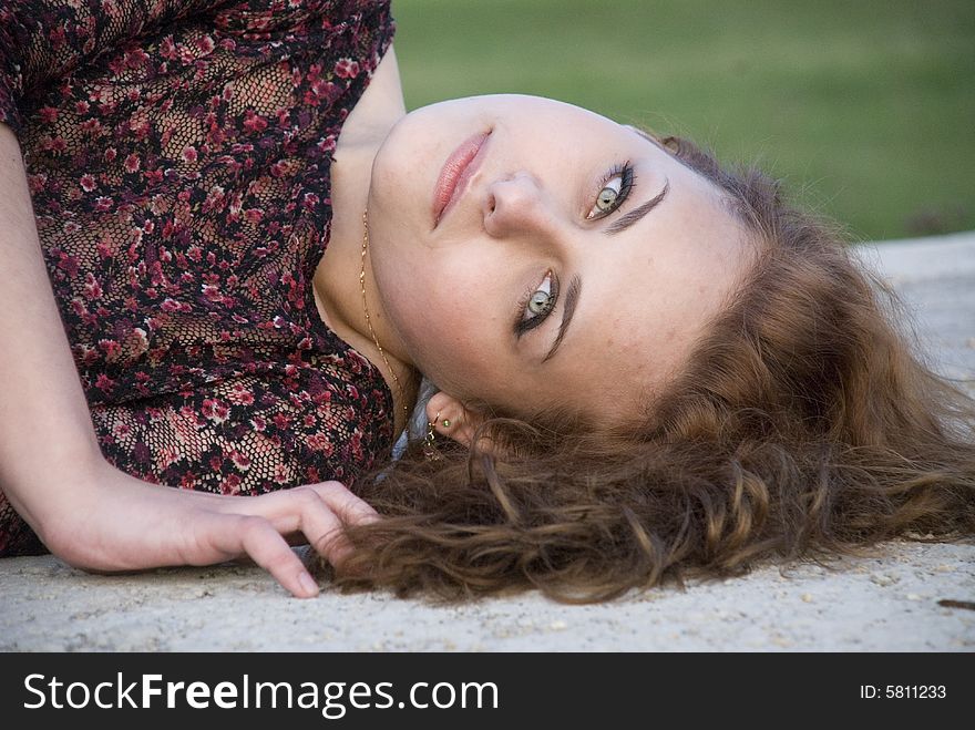 Portrait of young girl lying in a park on bedding. Portrait of young girl lying in a park on bedding