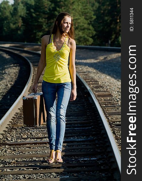 The young woman walks by rail