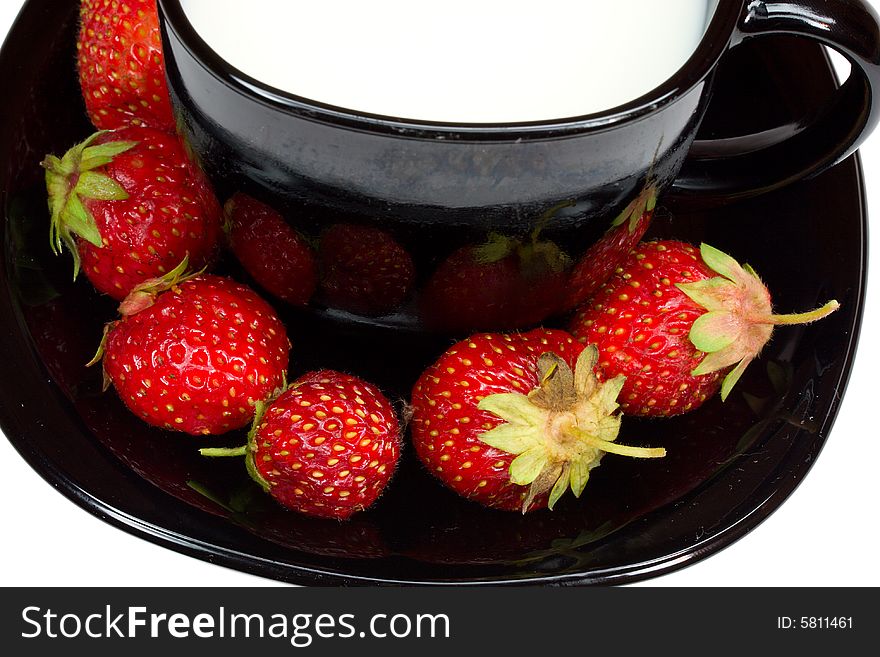 Close-up black cup of milk and strawberries, isolated on white