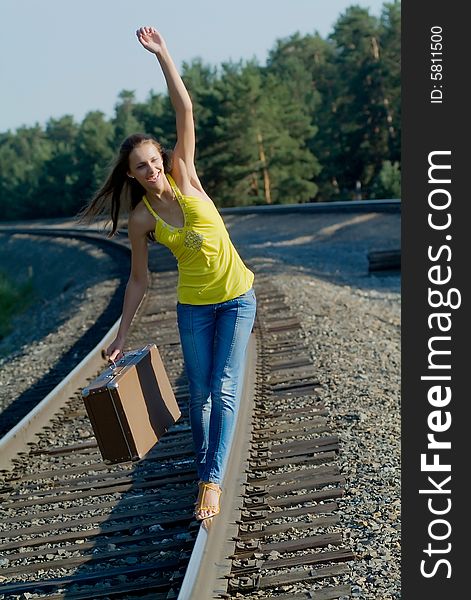 The young woman walks by rail