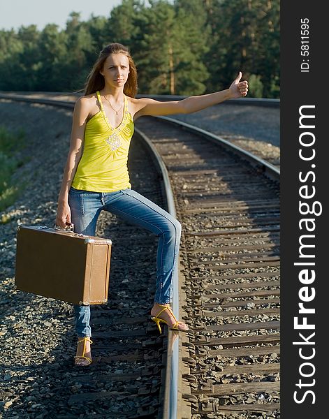 The young woman walks by rail