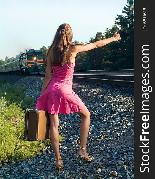 The young woman walks by rail