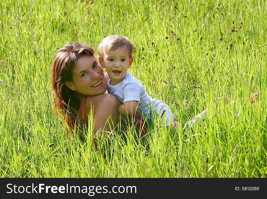 Happy mother and son playing in grass