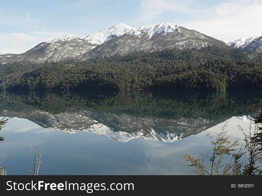 The mountains and the forest are reflected on the lake. The mountains and the forest are reflected on the lake