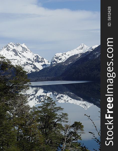 Snow-capped mountains are reflected on the lake. Snow-capped mountains are reflected on the lake