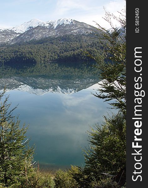 The mountains and the forest are reflected on the lake. The mountains and the forest are reflected on the lake