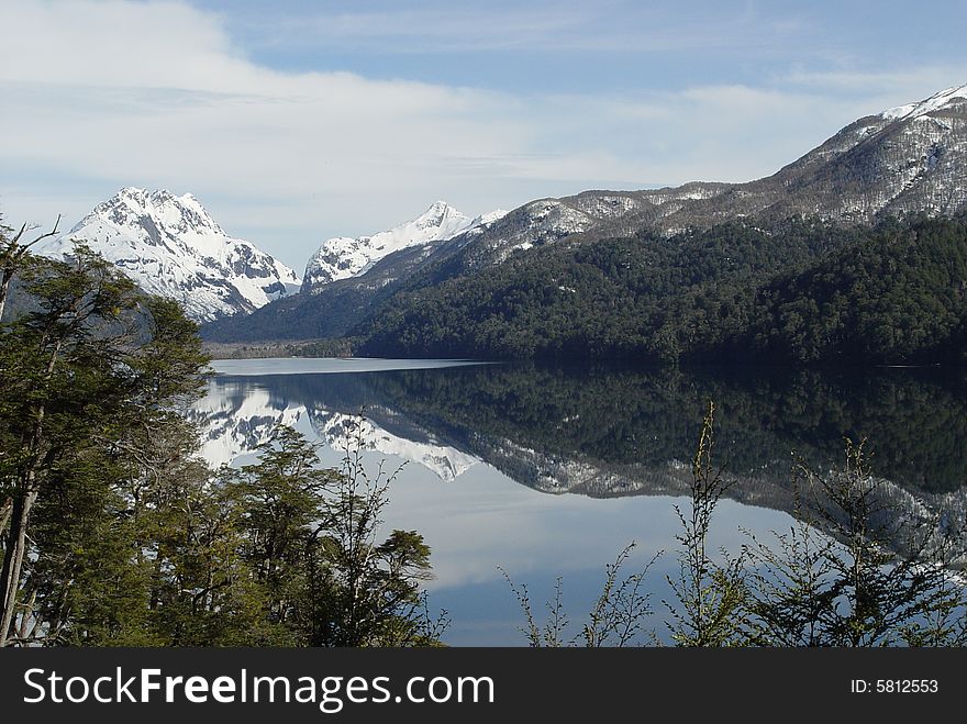 The mountains and the forest are reflected on the lake. The mountains and the forest are reflected on the lake