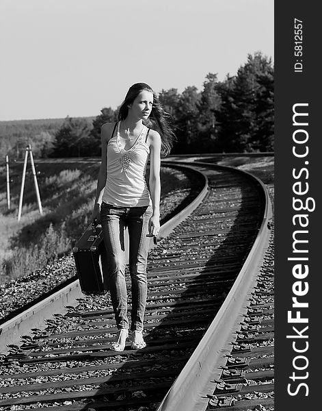 The young woman walks by rail