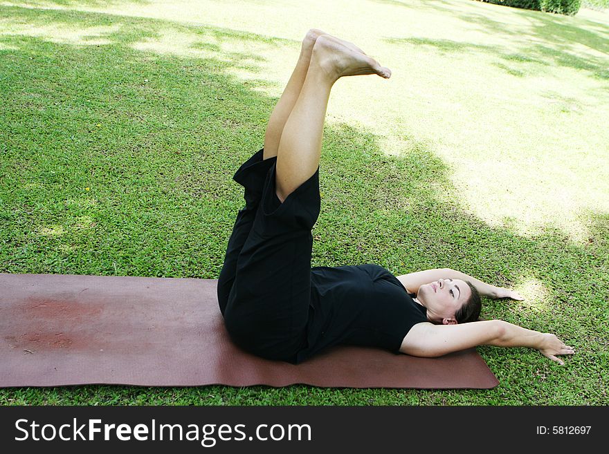 Young woman practicing yoga in the park.