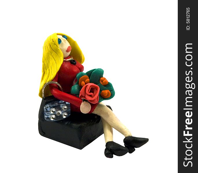 The plasticine blonde with a bouquet has a rest on a bench. The plasticine blonde with a bouquet has a rest on a bench