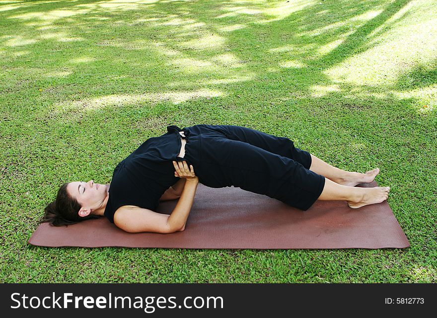 Young woman practicing yoga in the park.