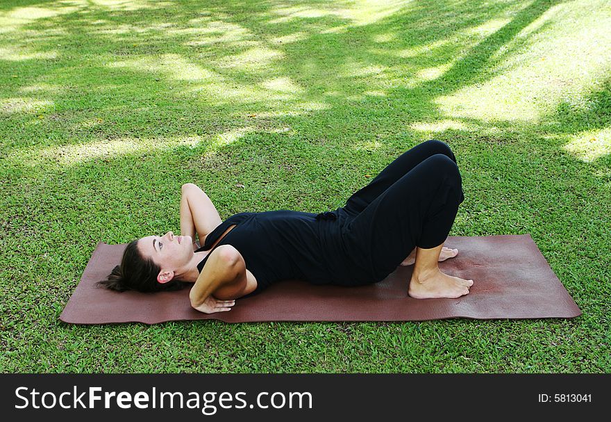 Young woman practicing yoga in the park.