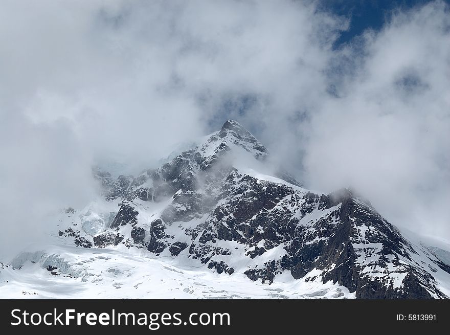 Snowy mountain in Yunan, China, under cloudy sky. Snowy mountain in Yunan, China, under cloudy sky