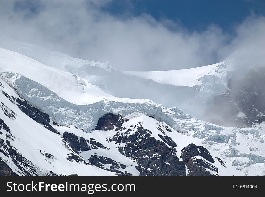 Snowy mountain in Yunan, China, under cloudy sky. Snowy mountain in Yunan, China, under cloudy sky