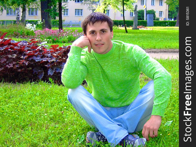 Photo of the young thoughtful person on a grass.