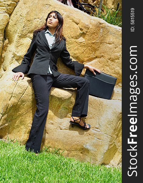 Young Businesswoman sitting on a rock wall. Young Businesswoman sitting on a rock wall