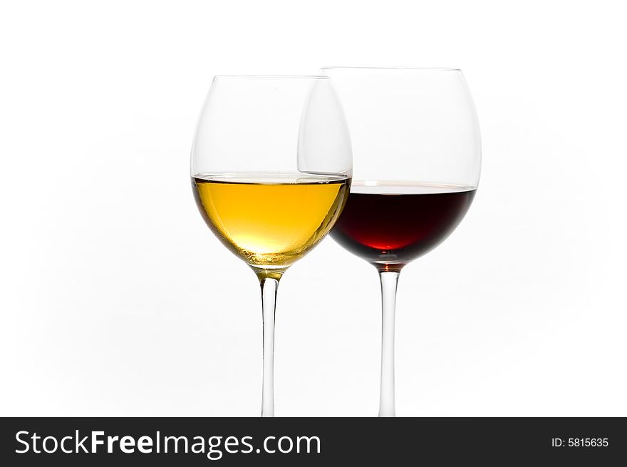 Two tall glasses on light background filled with red and white wine